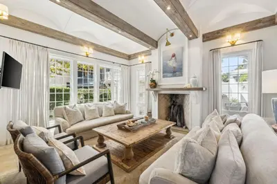 a living room with white furniture and a fireplace at Water Cottage and Carriage House in Rosemary Beach