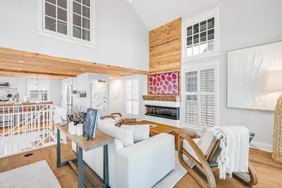 a living room with white walls and wooden ceilings at Atwoods Cottage & Carriage House in Rosemary Beach