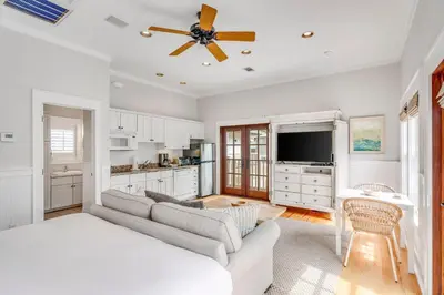 a living room with a couch and a ceiling fan at Hammock Carriage House in Rosemary Beach