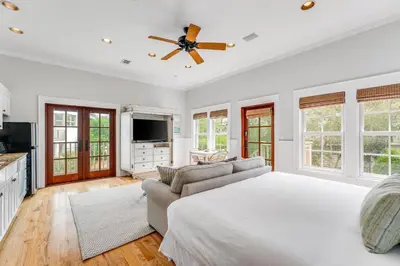 a bedroom with a large bed and a couch at Hammock Carriage House in Rosemary Beach