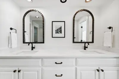 a white bathroom with two sinks and two mirrors at High Pointe 44W in Seacrest