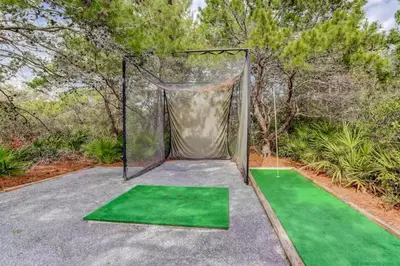 a batting cage with green mats on a golf course at High Pointe 44W in Seacrest