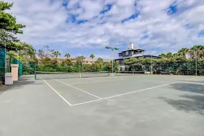 a tennis court with a house in the background at High Pointe 44W in Seacrest
