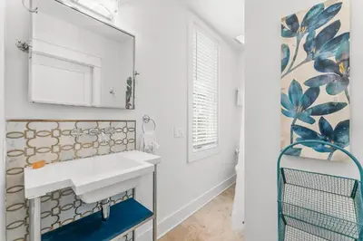 a bathroom with a white sink and a mirror at Southern Seaside Cottage and Carriage House in Inlet Beach