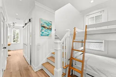 a white room with a staircase and a bed at Southern Seaside Cottage and Carriage House in Inlet Beach