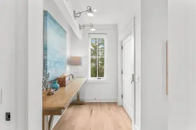 a hallway with a table and a window at Southern Seaside Cottage and Carriage House in Inlet Beach