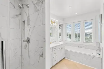 a white bathroom with a tub and a shower at Southern Seaside Cottage and Carriage House in Inlet Beach