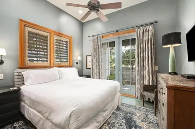 a bedroom with a large bed and a window at Villa Rose Cottage in Rosemary Beach