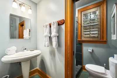 a bathroom with a sink and a toilet and a mirror at Villa Rose Cottage in Rosemary Beach