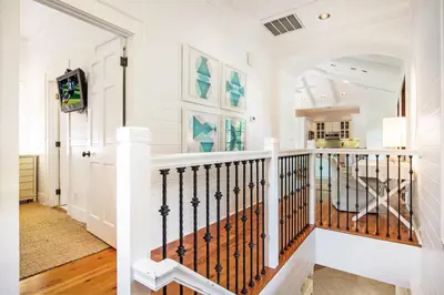 a staircase in a home with white walls at Hammock Cottage in Rosemary Beach