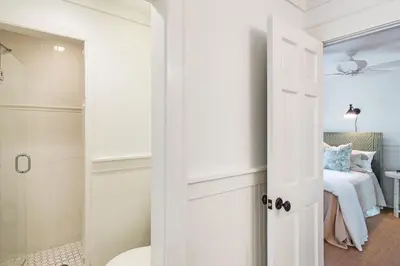a bathroom with a white door leading to a bedroom at Hammock Cottage in Rosemary Beach