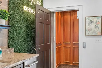 a hallway with a brown door and a green wall at Thyme & Place in Rosemary Beach