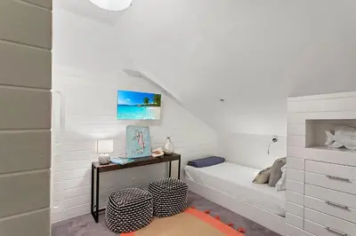 a white bedroom with a bed and a desk at Thyme & Place in Rosemary Beach