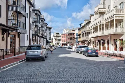 a city street with cars parked on a cobblestone road at Thyme & Place in Rosemary Beach