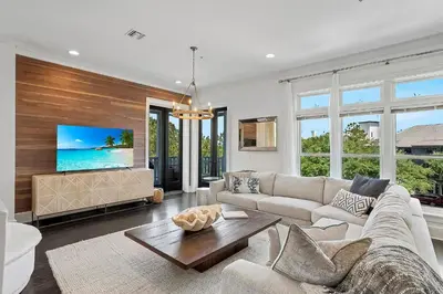a living room with a couch and a tv at Thyme & Place in Rosemary Beach