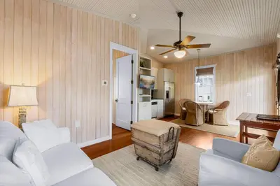 a living room with a couch and a table at Uncorked Carriage House in Rosemary Beach