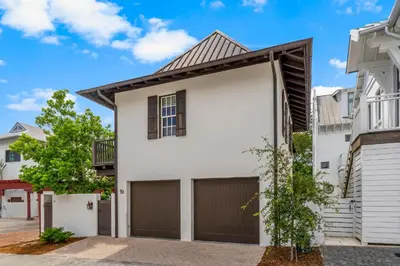 a white house with a garage at Uncorked Carriage House in Rosemary Beach