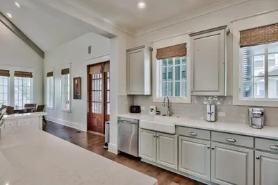 a kitchen with white cabinets and a sink at Southern Serenity Cottage in Rosemary Beach