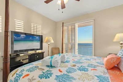 a bedroom with a television and a bed with towels at Beachfront Bliss Awaits: 2-Bed, 2-Bath Condo at Sterling Reef - Sleeps 6! in Panama City Beach