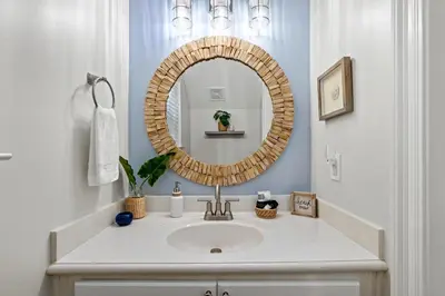 a bathroom with a sink and a mirror at Escape to Sand Dollar Holler: Coastal Retreat, 3 Beds, 25 Baths, Sleeps 10! in Panama City Beach