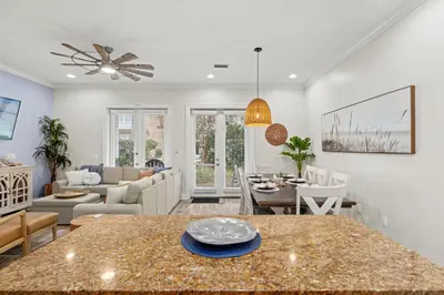a kitchen and living room with a table and chairs at Escape to Sand Dollar Holler: Coastal Retreat, 3 Beds, 25 Baths, Sleeps 10! in Panama City Beach