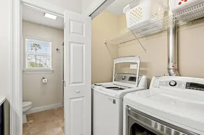 a laundry room with a washer and dryer at Escape to Sand Dollar Holler: Coastal Retreat, 3 Beds, 25 Baths, Sleeps 10! in Panama City Beach