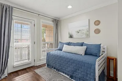 a bedroom with a bed and two windows at Escape to Sand Dollar Holler: Coastal Retreat, 3 Beds, 25 Baths, Sleeps 10! in Panama City Beach