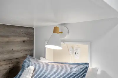 a bedroom with a blue and white pillow and a light fixture at Escape to Sand Dollar Holler: Coastal Retreat, 3 Beds, 25 Baths, Sleeps 10! in Panama City Beach