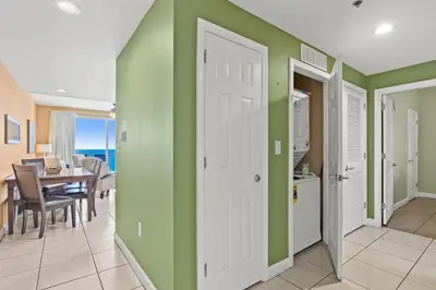 a kitchen and dining room with green walls and a table at Anchor's Way! Come Visit Our Beautiful 2 BR, 2BA Oceanfront Retreat! Sleeps 6! in Panama City Beach