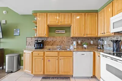 a kitchen with wooden cabinets and white appliances at Anchor's Way! Come Visit Our Beautiful 2 BR, 2BA Oceanfront Retreat! Sleeps 6! in Panama City Beach