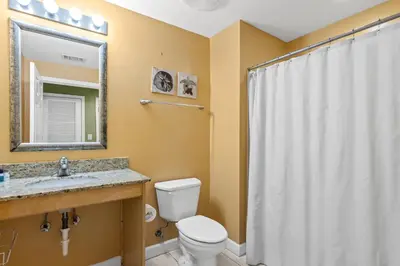 a bathroom with a toilet and a sink and a mirror at Anchor's Way! Come Visit Our Beautiful 2 BR, 2BA Oceanfront Retreat! Sleeps 6! in Panama City Beach