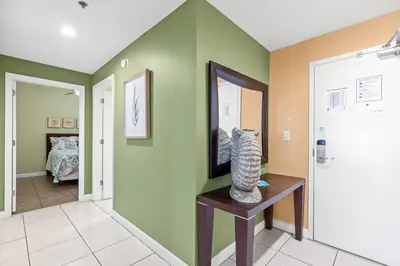a hallway with green walls and a vase on a table at Anchor's Way! Come Visit Our Beautiful 2 BR, 2BA Oceanfront Retreat! Sleeps 6! in Panama City Beach
