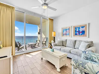 a living room with a couch and a view of the ocean at Aqua Resort 706 in Panama City Beach