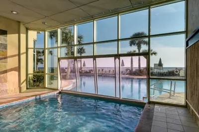 an indoor swimming pool in a building with large windows at Aqua Resort 706 in Panama City Beach