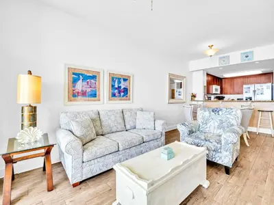 a living room with a couch and a chair at Aqua Resort 706 in Panama City Beach