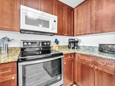 a kitchen with a stove and a microwave at Aqua Resort 706 in Panama City Beach