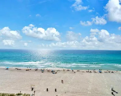 a group of people on a beach near the ocean at Aqua Resort 706 in Panama City Beach