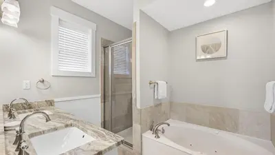 a white bathroom with a tub and a sink at 30A Emerald Waters by AvantStay Pool Bikes Bonfires in Panama City Beach