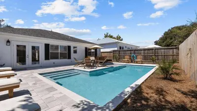 a swimming pool in the backyard of a house at Walk to Beach Golf Cart Bikes Pool Fire Pit Bonfires G By The Sea by AvantStay in Panama City Beach