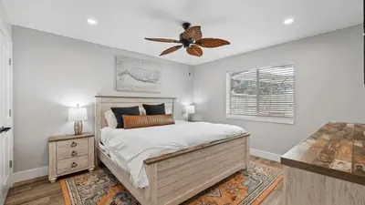a bedroom with a bed and a ceiling fan at Walk to Beach Golf Cart Bikes Pool Fire Pit Bonfires G By The Sea by AvantStay in Panama City Beach