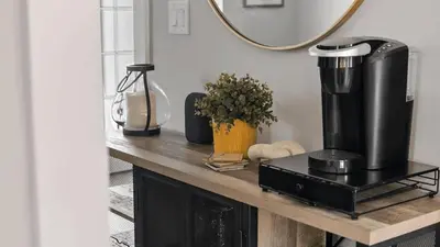a counter with a coffee maker on a table with a mirror at Walk to Beach Golf Cart Bikes Pool Fire Pit Bonfires G By The Sea by AvantStay in Panama City Beach