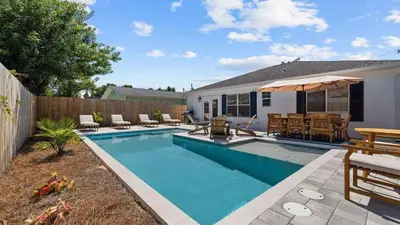 a swimming pool in the backyard of a house at Walk to Beach Golf Cart Bikes Pool Fire Pit Bonfires G By The Sea by AvantStay in Panama City Beach