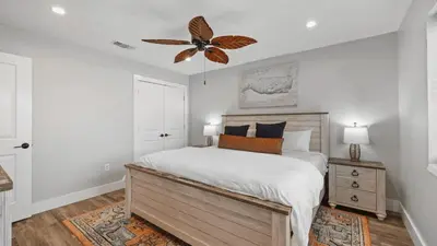 a bedroom with a bed and a ceiling fan at Walk to Beach Golf Cart Bikes Pool Fire Pit Bonfires G By The Sea by AvantStay in Panama City Beach