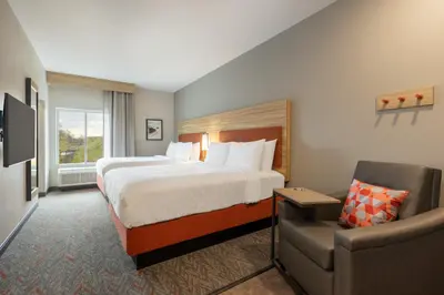 a hotel room with a bed and a chair at Candlewood Suites Panama City - Tyndall AFB by IHG in Panama City