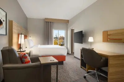 a hotel room with a bed and a desk at Candlewood Suites Panama City - Tyndall AFB by IHG in Panama City