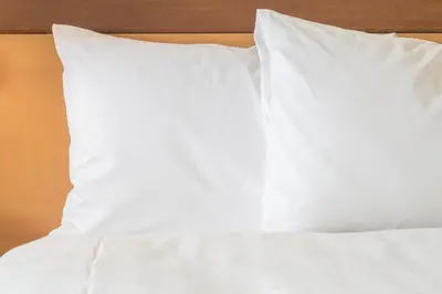 a bed with white sheets and pillows on it at Candlewood Suites Panama City - Tyndall AFB by IHG in Panama City