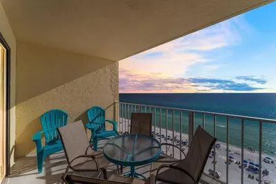 a balcony with chairs and a table and the ocean at Regency Towers 1212 by Emerald Coast Retreats in Panama City Beach