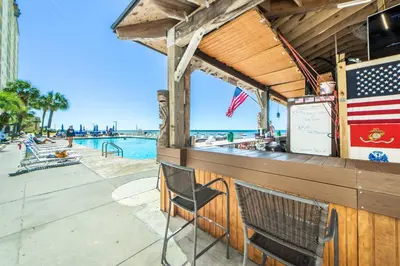 a bar with an american flag on it next to the water at Regency Towers 1212 by Emerald Coast Retreats in Panama City Beach