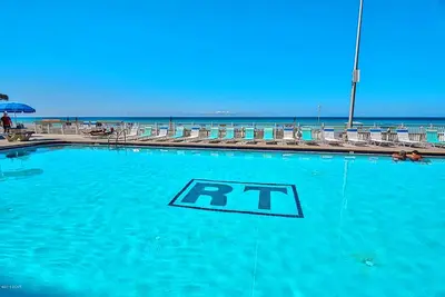 a swimming pool with an rt sign in front of the beach at Regency Towers 1212 by Emerald Coast Retreats in Panama City Beach