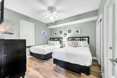 a bedroom with two beds and a ceiling fan at Grandview East 1002 in Panama City Beach